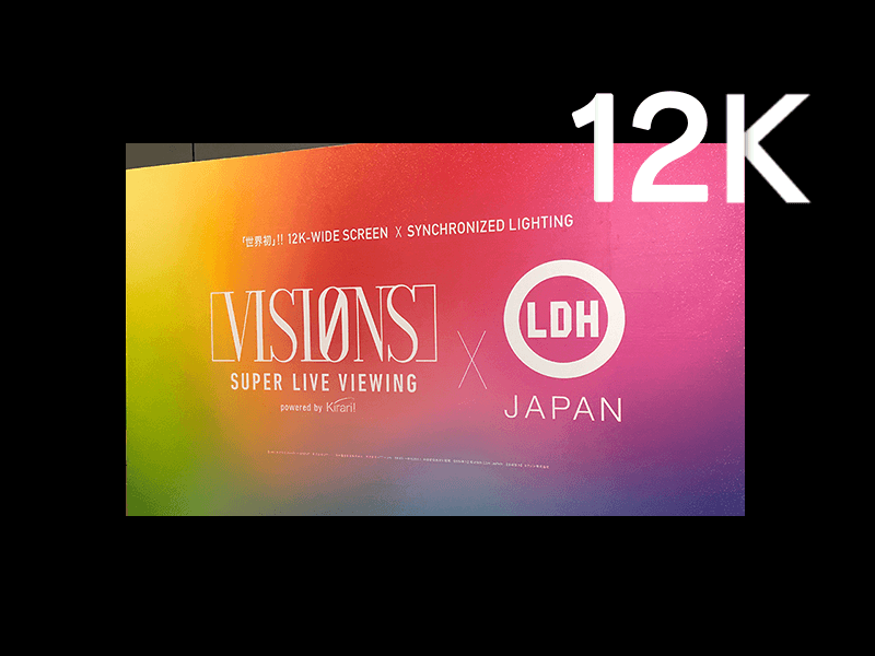 2019年3月24日、東京国際フォーラムにて開催された、未来型スーパーライブビューイング「VISIONS」。世界初：12Kワイド映像と照明や電飾の信号を同期伝送することで、LDH所属アーティスト「EG-Family」の山形でのライブを東京会場に設置した、横30ｍを超える超大型スクリーンにリアルに再現。フルスコアは当日の中継業務とメイキング撮影を担当しました。